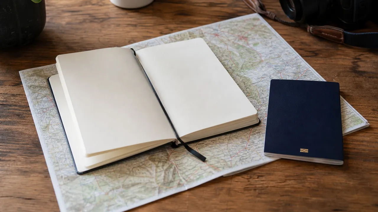 Carnet de voyage, carte et passeport sur un bureau en bois